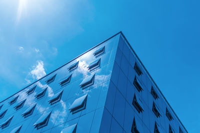 Low angle view of modern building against blue sky