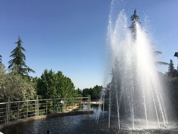 Water splashing in fountain against clear sky