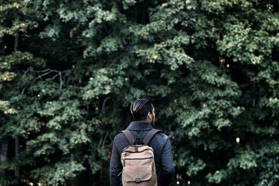 Woman standing on tree trunk in forest