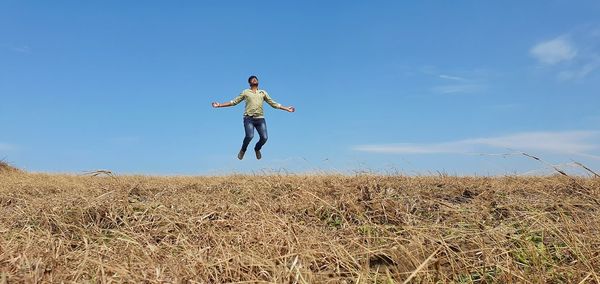 Full length of person paragliding on field against sky