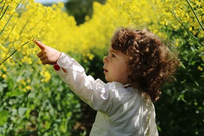 Side view of girl holding flowering plant