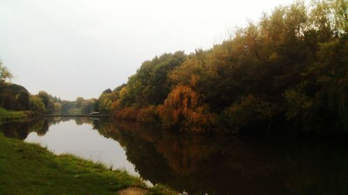 Reflection of trees in lake against clear sky