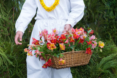 Midsection of man holding flowers in basket