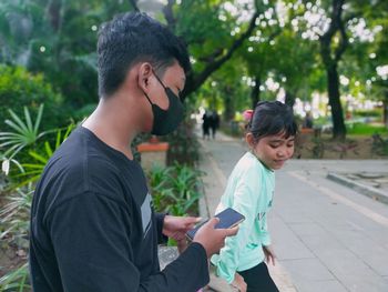 Father and son using mobile phone outdoors