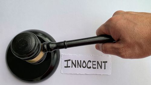 Close-up of hand holding gavel on table