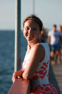 Portrait of smiling woman against sea