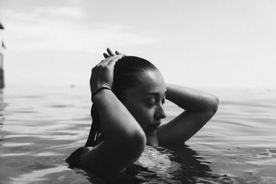 Woman swimming in sea against sky