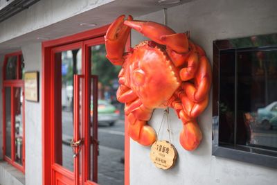 Close-up of red bell hanging on window