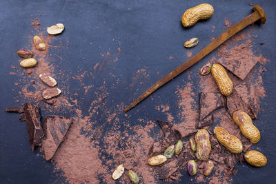 Directly above shot of chocolates and nuts by nail on table