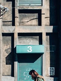 Rear view of woman standing at entrance of building