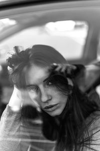 Portrait of woman in car seen through window