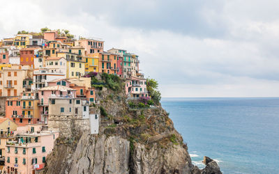 Buildings by sea against sky