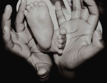 Close-up of father holding baby feet