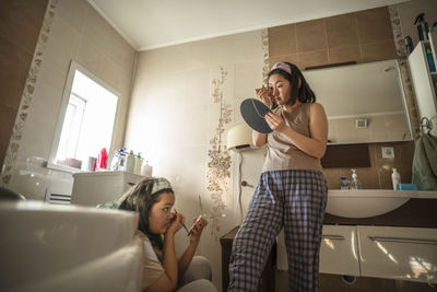 Asian young beauties start morning routine with makeup and removal of unwanted hair in bathroom
