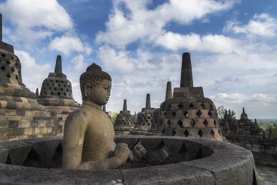 Statue of temple in building against sky