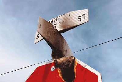 Low angle view of sign board against sky