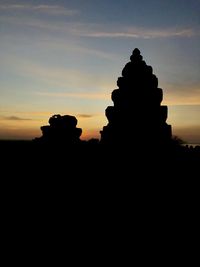 Silhouette cross against sky during sunset