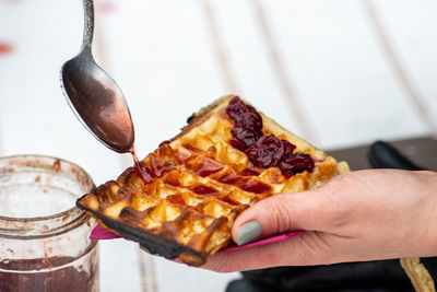 Cropped hand of woman holding food