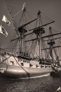 Sailboats moored in sea against sky