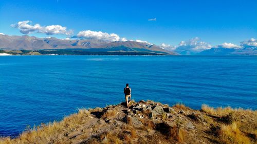 Rear view of man looking at sea against sky