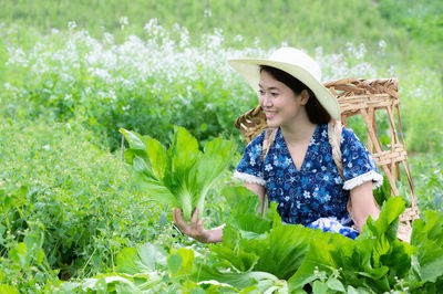 Woman wearing hat and plants on field