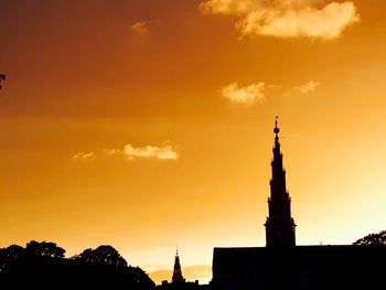 Low angle view of silhouette built structure against sunset sky