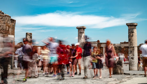 Street photography in ancient pompeii. rear view of people walking on street