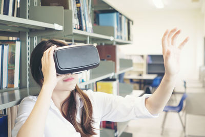 Female student using virtual reality simulator in library