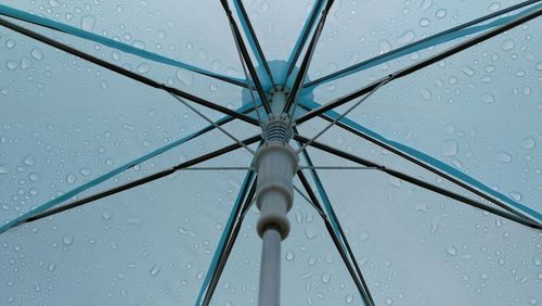 Low angle view of raindrops against blue sky