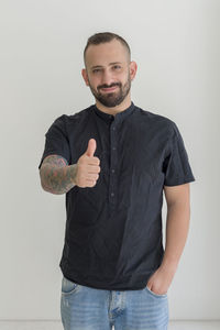 Portrait of young man standing against white background