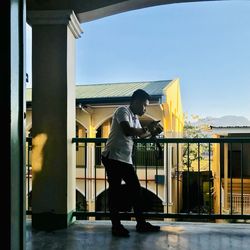 Side view of man photographing against clear sky