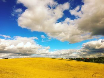 Scenic view of field against cloudy sky