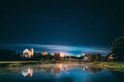 Scenic view of lake against sky at night