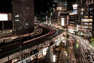 High angle view of light trails on street amidst buildings in city