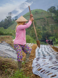 Rear view of woman holding umbrella