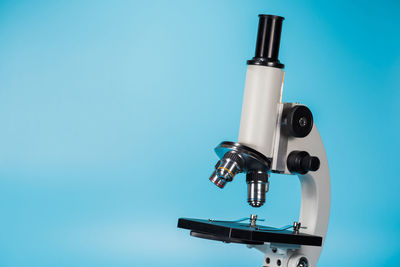 Close-up of microscope on blue background