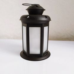 Close-up of lantern on table against wall at home