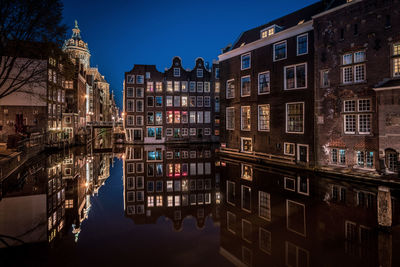 Reflection of buildings in canal at dusk