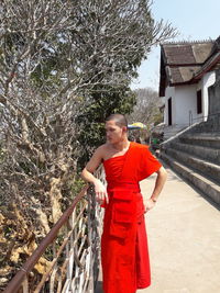 Young man standing against trees