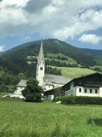 Scenic view of building by mountains against sky