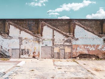 Graffiti on wall of old building against sky