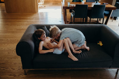 High angle view of friends sitting on wooden floor