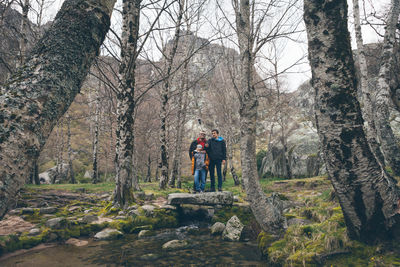 Father with sons taking selfie in forest