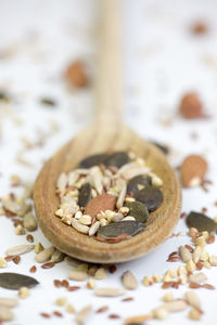 Close-up of dried food in in wooden spoon over white background