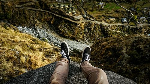 Low section of man relaxing on rock