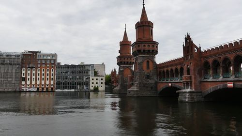 Arch bridge over river against buildings in city