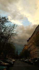 View of city street against cloudy sky