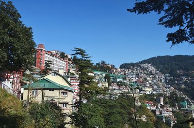 Houses in town against clear blue sky