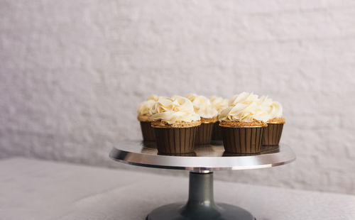 Close-up of cupcakes on table against wall