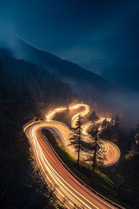 High angle view of light trails on road against sky at night